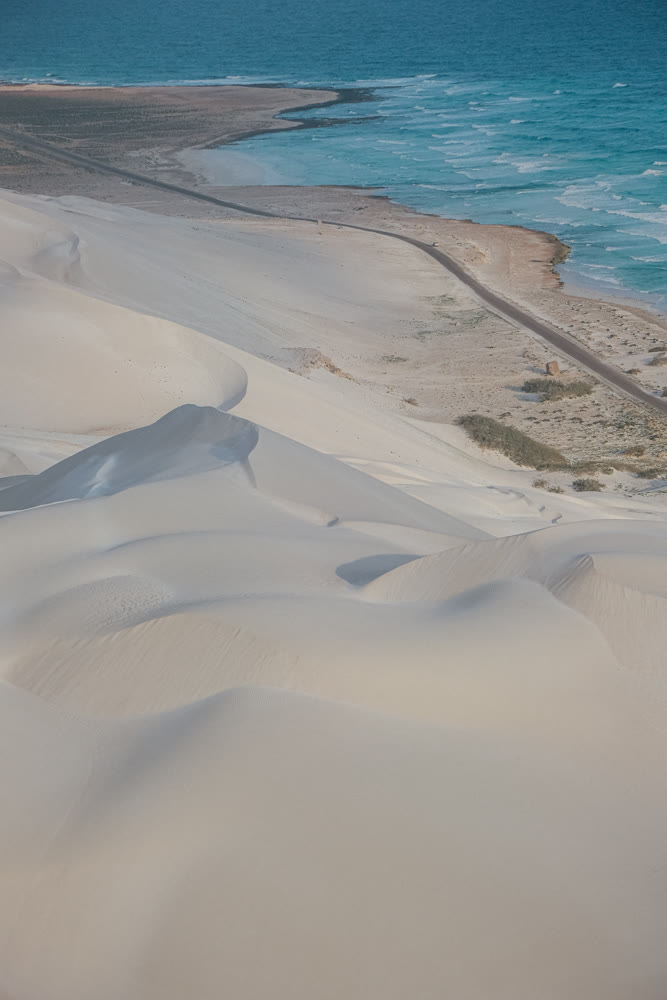 Quiet coastal sands from above. Remote aerial perspective of peaceful sandy coast and gentle waves