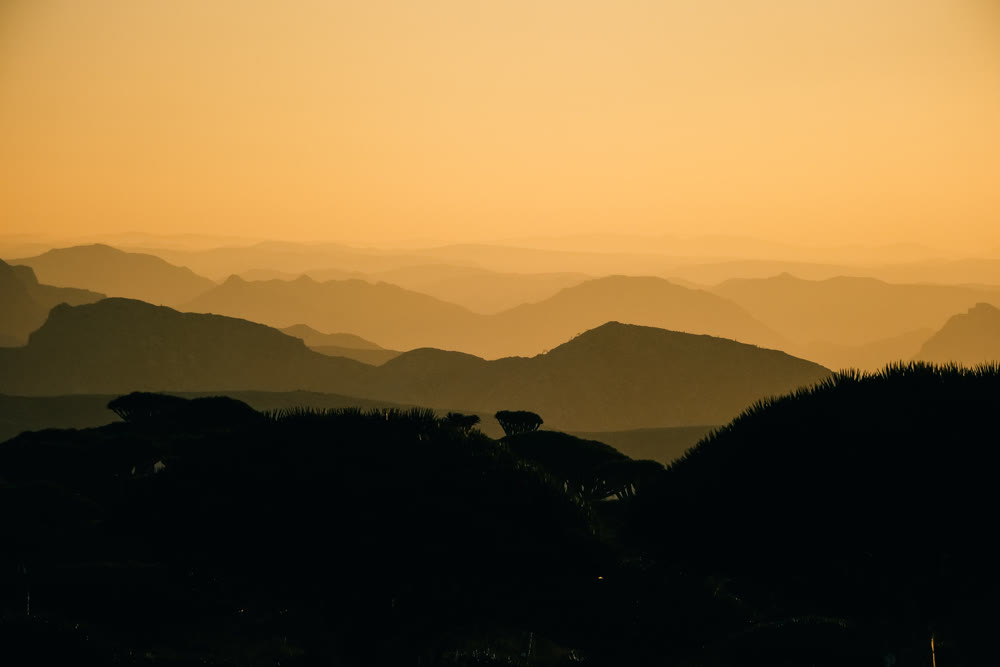Evoking serene views. Hazy mountain ranges fade into tranquil valleys illuminated by gentle sunlight