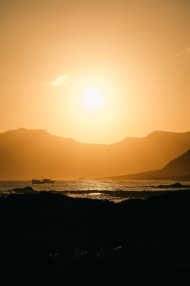 Sun sets beautifully. Evening glow shapes coastlines with bright reflections and tranquil atmosphere